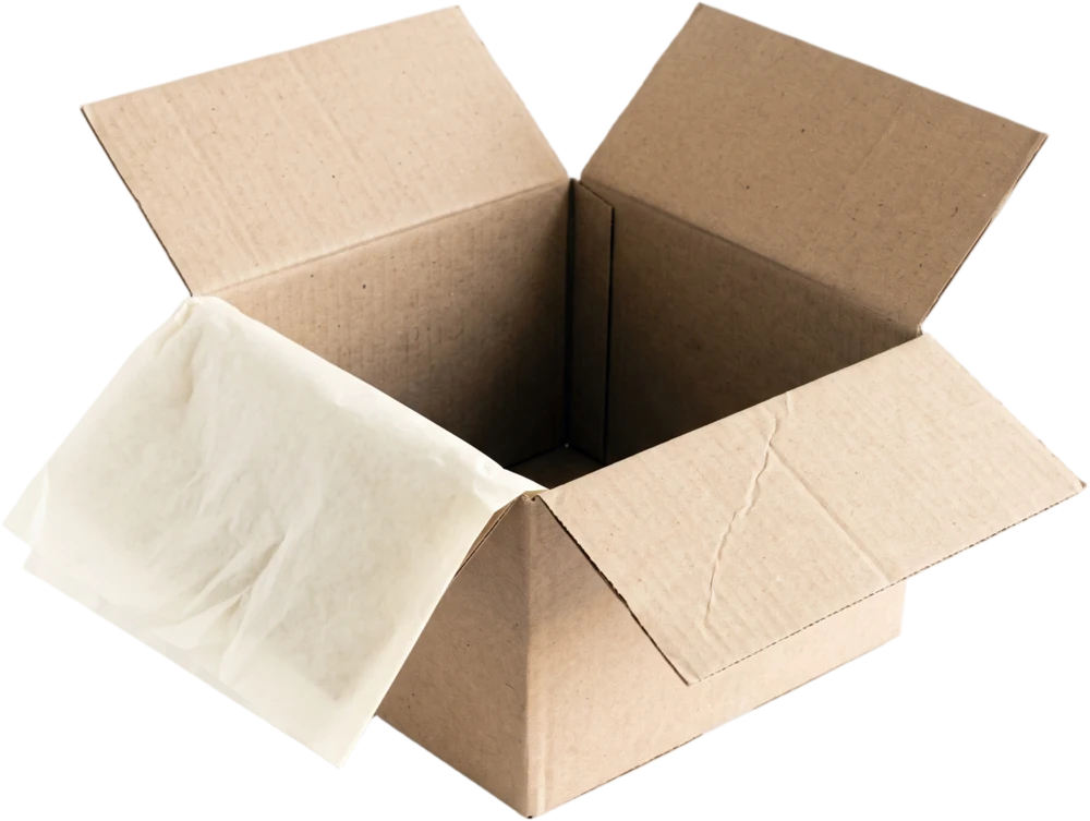 A shallow open shipping box in plain kraft card, empty, with a sheet of ivory tissue draped over one edge
