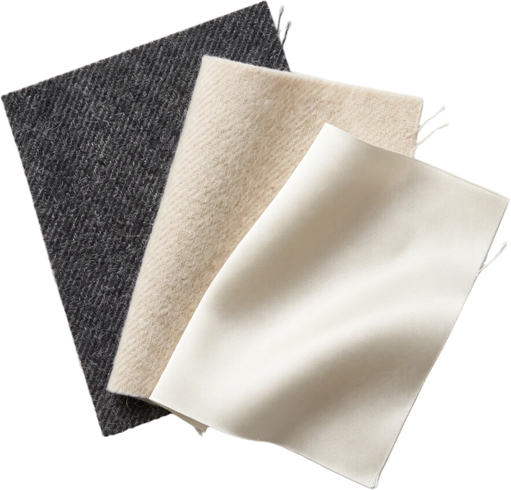 Three fabric swatches fanned out, charcoal wool flannel, oat cashmere and bone silk